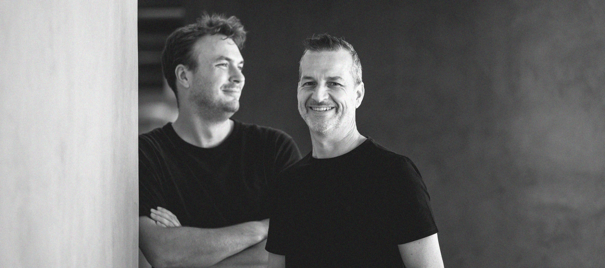Two members of the humbl. team in black T-shirts, smiling, in the studio